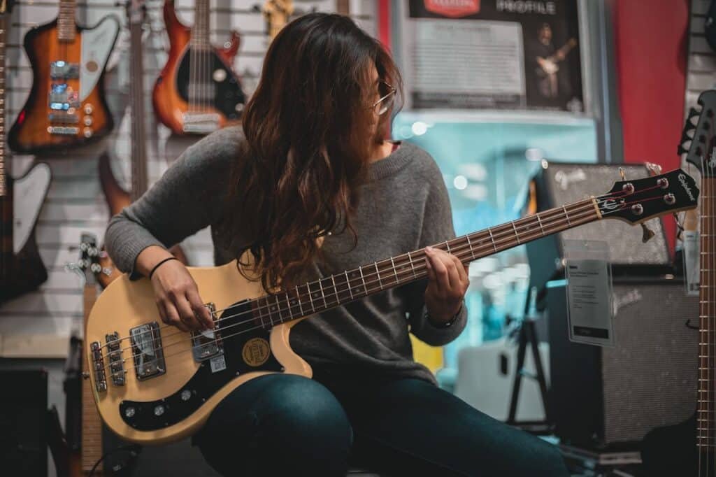 woman playing bass in one of the best guitar stores in europe