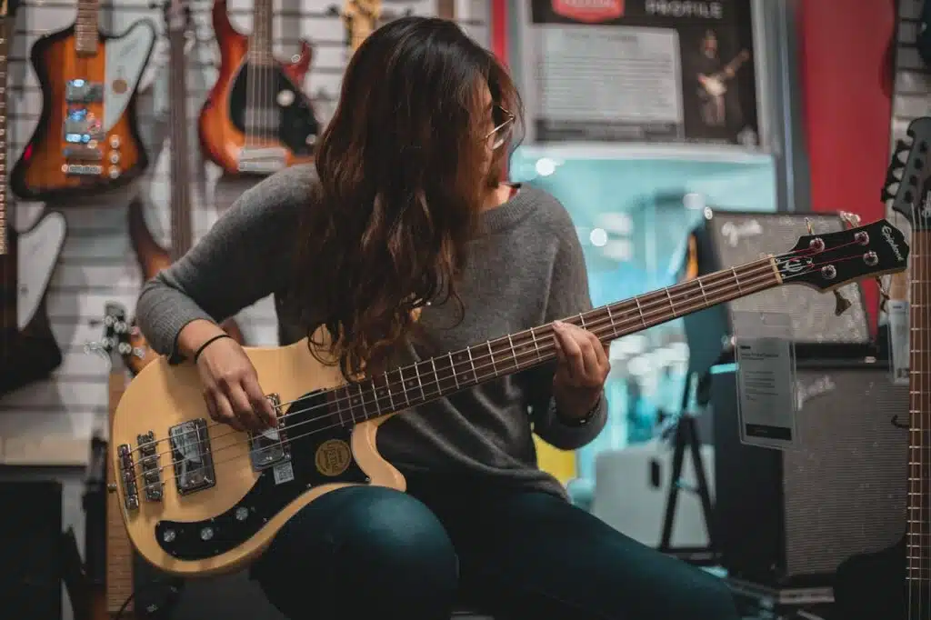 woman playing bass in one of the best guitar stores in europe