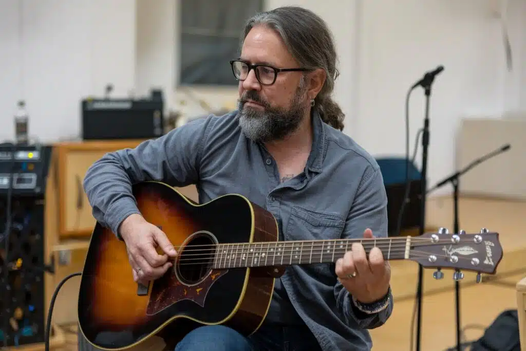 man playing on acoustic guitar