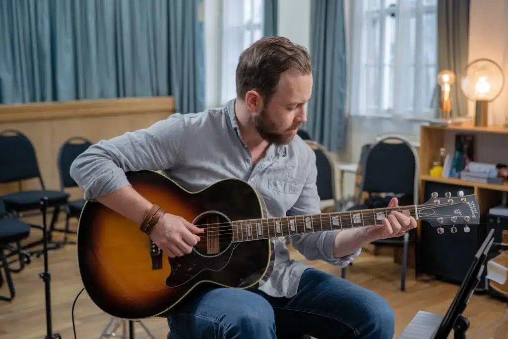 man playing on acoustic guitar